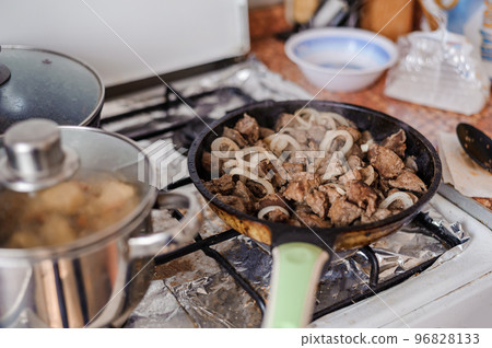 Fried veal liver with onions in a pan. Braised cow and pork liver Fried veal liver with onions in a pan. Braised cow and pork liver 96828133
