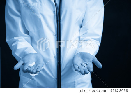 Cropped view of female Doctor holding in hands Pills to choose. Difficult Choice between drugs. Placebo drugs concept. Healthcare concept. 96828688