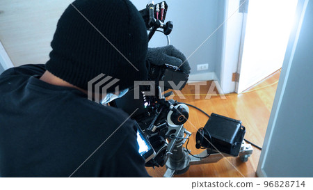 Behind the scenes of Videographer or photographer shooting video or movie production with camera set on tripod at indoor location. Director of Photography or DOP DP working in movie production set. 96828714