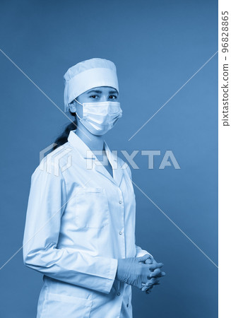 Young doctor against dark blue background, studio shot with copy space 96828865