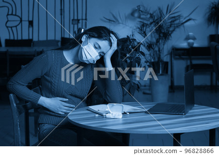 sick woman with pills and thermometer on a table working on a laptop from home on quarantine isolation. sick woman with pills and thermometer on a table working on a laptop from home on quarantine isolation. 96828866