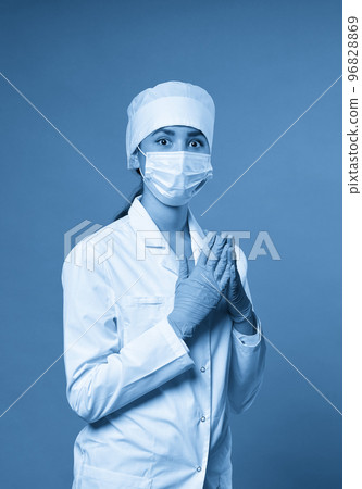 Young doctor against dark blue background, studio shot with copy space Young doctor against dark blue background, studio shot with copy space 96828869