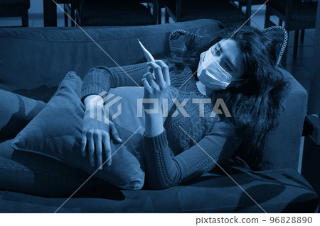 young woman holding thermometer on sofa got fever, caught, sick girl having influenza symptoms, flu or virus concept 96828890