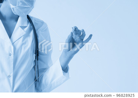 Doctor wearing face mask looking at measurement on medical thermometer over white background with copy space 96828925