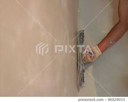 space for text on the blurred space of the wall that the builder is plastering in the distance, a banner with a copy-paste on the theme of repair interior work space for text on the blurred space of the wall that the builder is plastering in the distance, a banner with a copy-paste on the theme of repair interior work 96829033