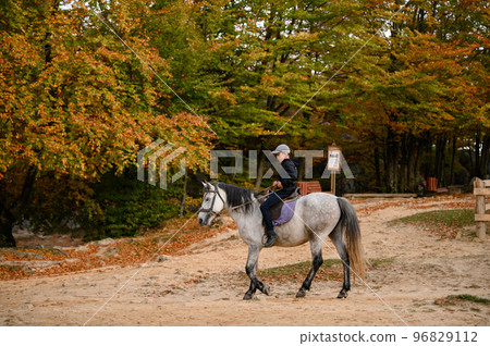 A school-age boy rides a horse in the Dovbush rock park in Ukraine. 96829112