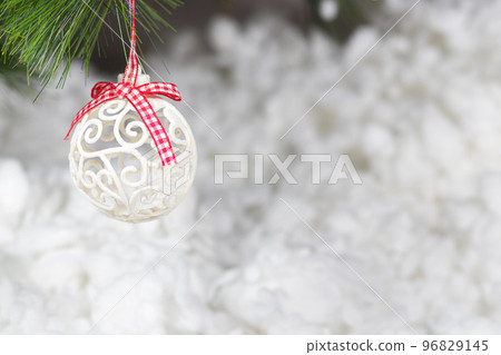 A white Christmas ball and a snow-covered tree branch on a snowy white background. Horizontal card place for copy space text A white Christmas ball and a snow-covered tree branch on a snowy white background. Horizontal card place for copy space text 96829145