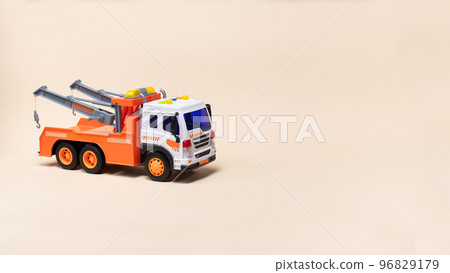 Toy orange tow truck on beige background banner with space for text. Children's car for loading and transporting cars. Toy orange tow truck on beige background banner with space for text. Children's car for loading and transporting cars. 96829179