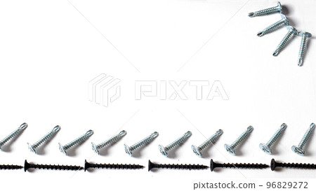Self-cutters on a white background banner with space for text. Construction tools, self-tapping screws for fastening. Black screw hardware. 96829272