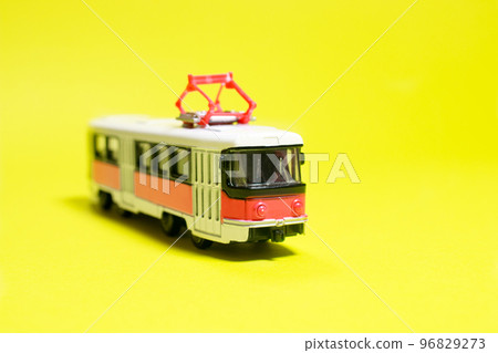 Children's toy red white tram on a yellow background copy space for text. Toys for a toy store, cars for a boy. Children's toy red white tram on a yellow background copy space for text. Toys for a toy store, cars for a boy. 96829273