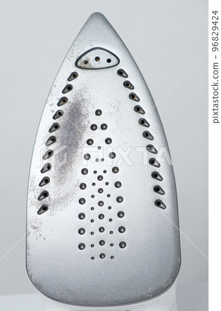 Damaged sole of the iron, brown stains and traces of burning with smoke and steam. Improper behavior during ironing clothes Damaged sole of the iron, brown stains and traces of burning with smoke and steam. Improper behavior during ironing clothes 96829424