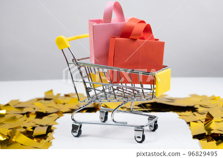 Shopping bags in a small shopping cart, sale concept. Shopping bags in a small shopping cart, sale concept. 96829495