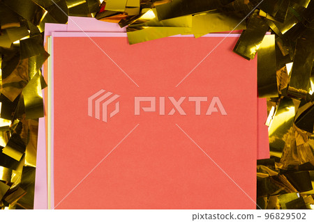 Red square sheet of paper on yellow sparkles, space for text, top view. 96829502