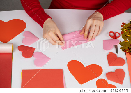 Making origami hearts for Valentine's Day. Crafts made of paper with your own hands. 96829525