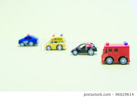 Toy plastic little cars on a light yellowish background with a place for text. Toys for children Toy plastic little cars on a light yellowish background with a place for text. Toys for children 96829614