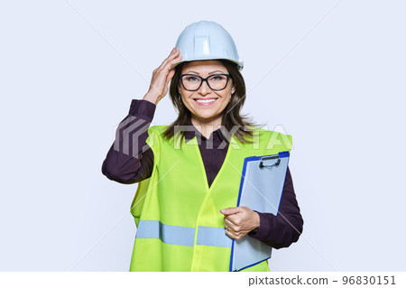 Professional woman in safety vest helmet holding clipboard on white background Professional woman in safety vest helmet holding clipboard on white background 96830151