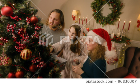 Happy family decorating Christmas tree with toys Happy family decorating Christmas tree with toys 96830307