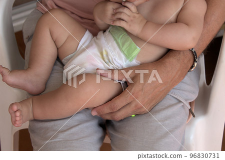 close-up of father holding his lovely baby on his lap close-up of father holding his lovely baby on his lap 96830731