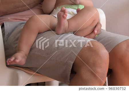 close-up of father holding his newborn on his lap close-up of father holding his newborn on his lap 96830732