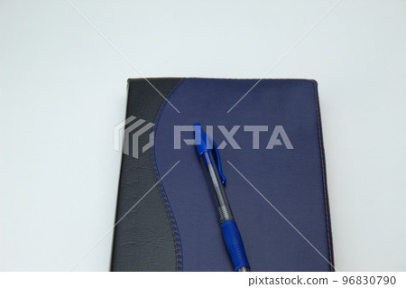 top view of a diary or notepad with a blue pen on top on white background with copy space top view of a diary or notepad with a blue pen on top on white background with copy space 96830790