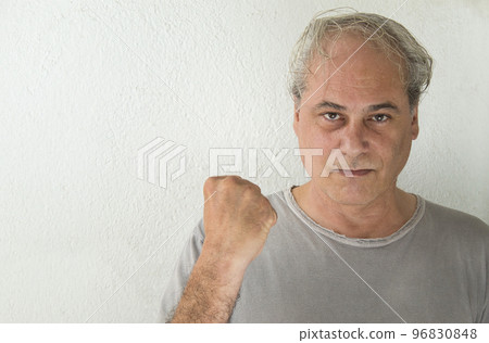 mature man looking at camera with raised fist in victory sign on white background mature man looking at camera with raised fist in victory sign on white background 96830848