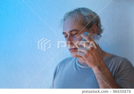 portrait with copy space of mature man with ambient color lights on white background refresh his face with cold drink 96830878