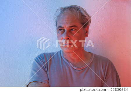 portrait with copy space of mature man with ambient color lights on a white background looking away portrait with copy space of mature man with ambient color lights on a white background looking away 96830884