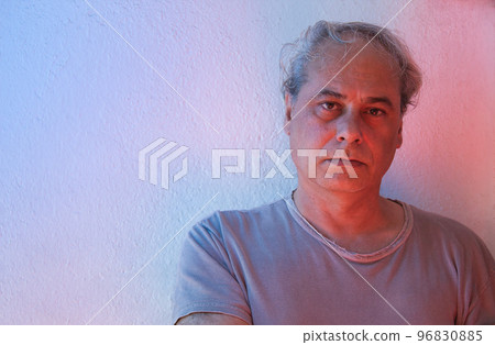 portrait with copy space of mature man with red and blue ambient color lights on a white background looking at camera portrait with copy space of mature man with red and blue ambient color lights on a white background looking at camera 96830885