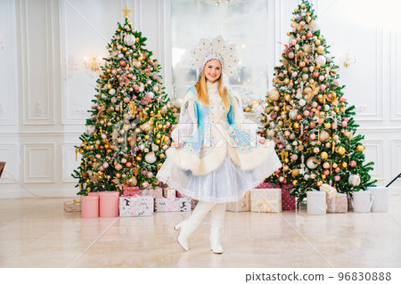 Snow Maiden in costume with short skirt and kokoshnik. room with christmas tree. 96830888