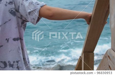 view of the seashore from a girl on a wooden ladder view of the seashore from a girl on a wooden ladder 96830953