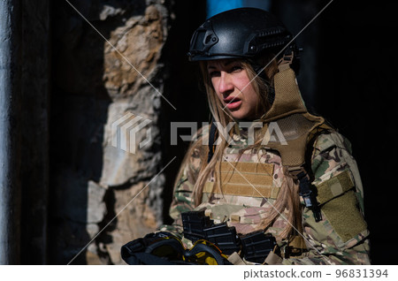 Portrait of a caucasian woman in a protective suit. Female FA soldier in camouflage uniform. Portrait of a caucasian woman in a protective suit. Female FA soldier in camouflage uniform. 96831394
