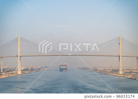 Huge cargo ships under Al Salam Bridge navigate by Suez Canal. Concept of transportation and logistics  96833174