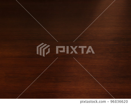 Background image of a delicate dark brown wood grain desk board with light obliquely from the upper right 96836620