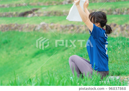 A Japanese woman who is a soccer fan and supporter cheering with a fan goods towel A Japanese woman who is a soccer fan and supporter cheering with a fan goods towel 96837868