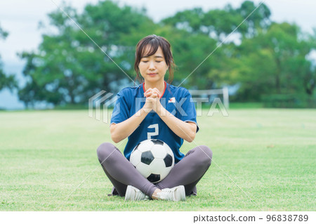 一位日本女性，她是一名足球迷和支持者，為日本國家隊歡呼，彷彿在祈禱 96838789