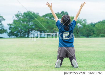 一名足球運動員在足球場上贏得五人制足球後欣喜若狂 一名足球運動員在足球場上贏得五人制足球後欣喜若狂 96839765