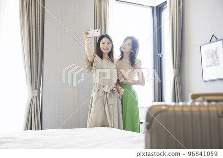 父母和孩子在他們下榻的酒店用智能手機拍攝紀念照 母女 全國旅行支持 96841059