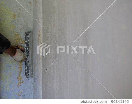 a banner with an empty space for text on a blurred surface of a plastered wall and a hand with a spatula in the background, copy paste on a smoothed wall texture in the process of puttying a banner with an empty space for text on a blurred surface of a plastered wall and a hand with a spatula in the background, copy paste on a smoothed wall texture in the process of puttying 96841343
