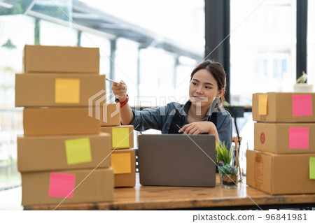 SME entrepreneur Small business entrepreneurs Online selling ideas, Happy Young Asian business owner work on computer and a boxes at home, delivery SME procurement package box deliver to customers SME entrepreneur Small business entrepreneurs Online selling ideas, Happy Young Asian business owner work on computer and a boxes at home, delivery SME procurement package box deliver to customers 96841981