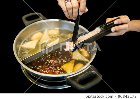 Top view of Fresh raw fish balls and Fresh raw shrimp balls put in the hot soup on black background, focus selective 96842172