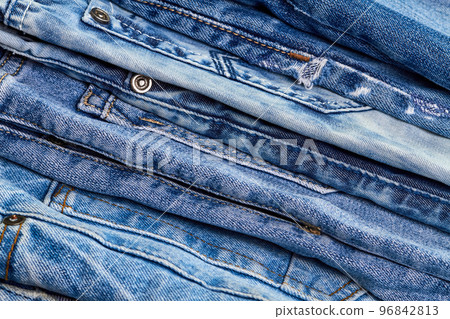 A stack of jeans as denim background or concept of buying, selling, shopping and trendy modern clothes A stack of jeans as denim background or concept of buying, selling, shopping and trendy modern clothes 96842813
