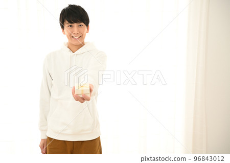 年輕人展示一個包裹好的禮盒 年輕人展示一個包裹好的禮盒 96843012