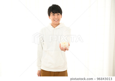 Young man presenting a wrapped gift box Young man presenting a wrapped gift box 96843013