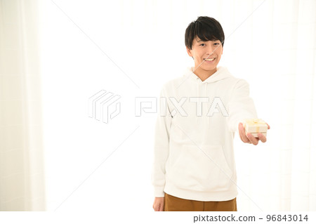 年輕人展示一個包裹好的禮盒 96843014
