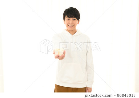 Young man presenting a wrapped gift box Young man presenting a wrapped gift box 96843015