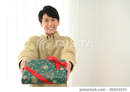 年輕人展示一個包裹好的禮盒 96843035