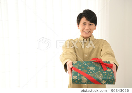 年輕人展示一個包裹好的禮盒 96843036