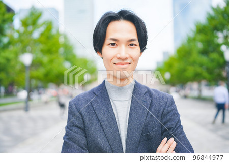 A man wearing a knitwear smiling in an office district 96844977