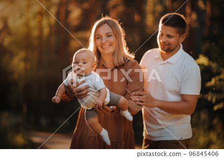 Happy family of three in the summer in the park in nature 96845406
