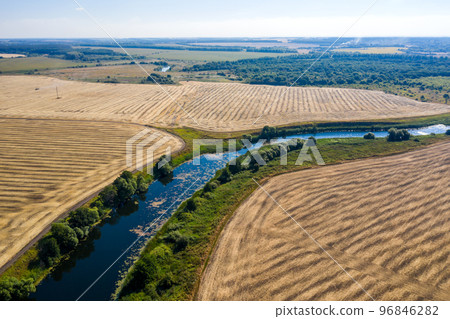 aerial photography of a bend in a river flowing through mown fields aerial photography of a bend in a river flowing through mown fields 96846282